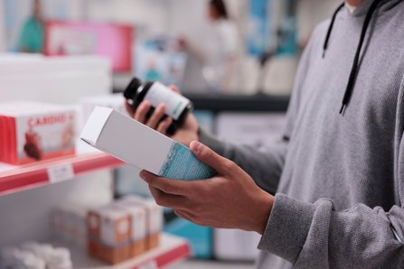 Man holding a box in a pharmacy