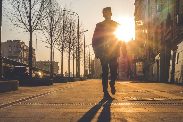 Man walking in a sunny city.
