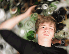 Young Man Surrounded by Bottles