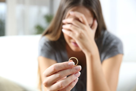 Women holding wedding ring in tears