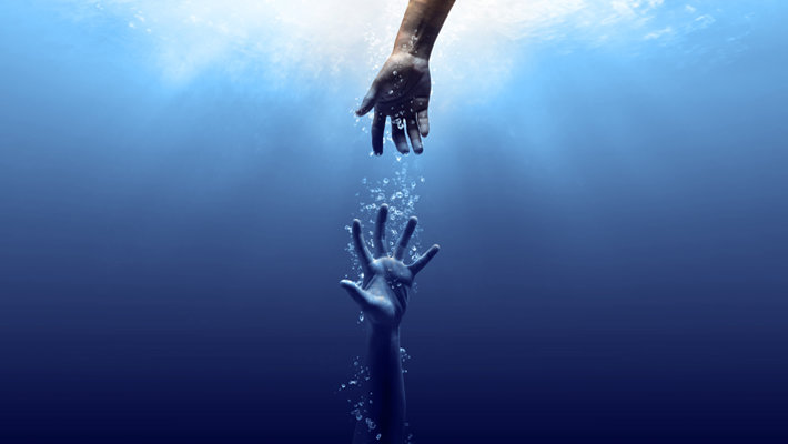 Hand reaching into the depths to help another